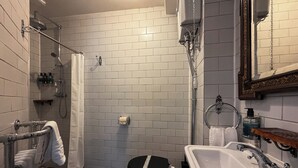 Un baño con piso a cuadros, inodoro, lavabo y ducha.