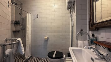 A bathroom with a checkered floor, a toilet, a sink, and a shower.