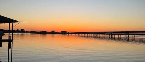 A calm body of water with a pier extending into it.