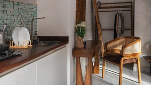 Eine Küche mit Holztisch, Spüle und Kleiderständer.