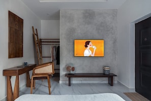 A modern interior with a grey concrete wall, a wooden chair, a bench, and a framed artwork. - The Mercy Studio - near Wuse 2, Maitama (Abuja)