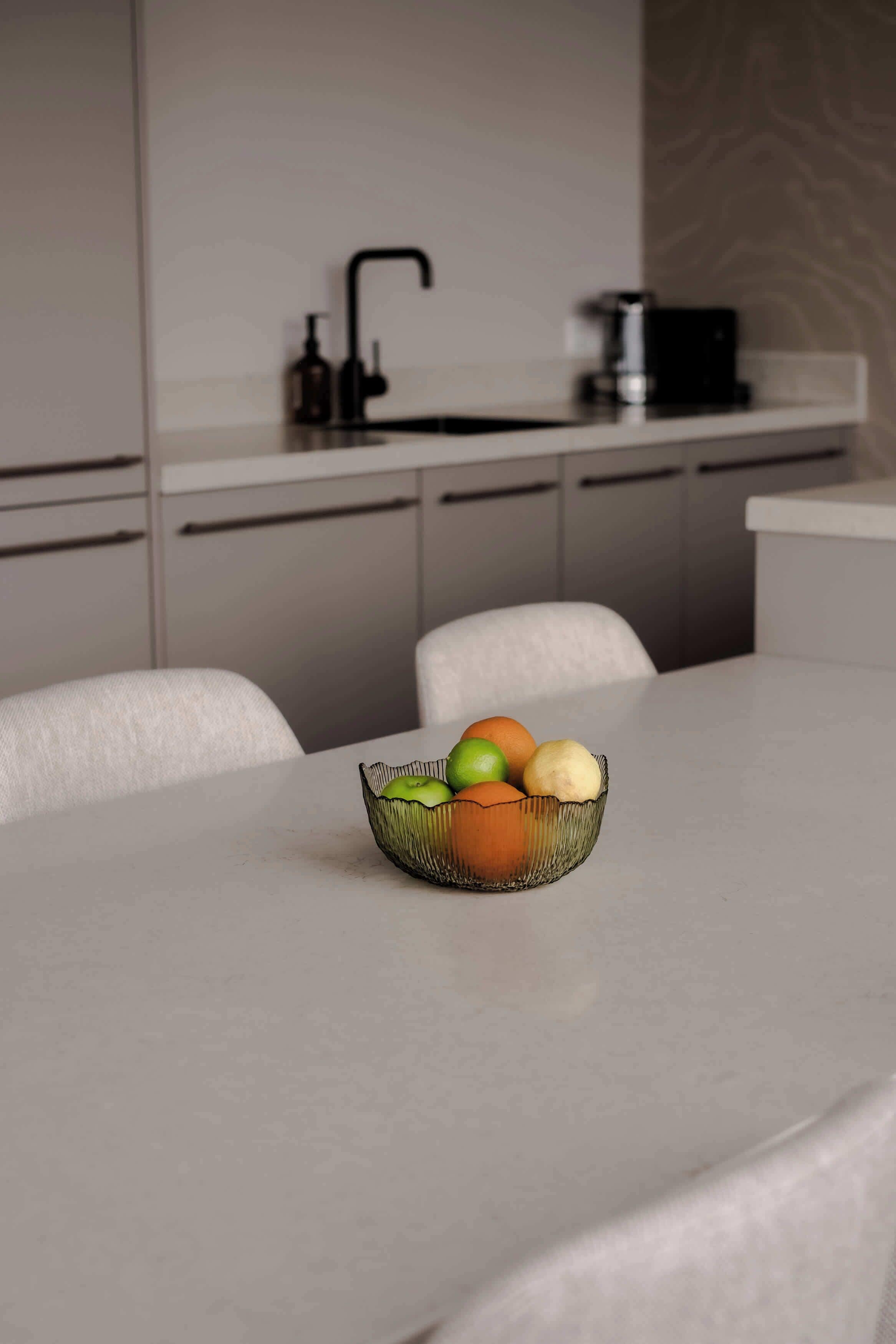 A modern kitchen with a white countertop, a sink, and cabinets.