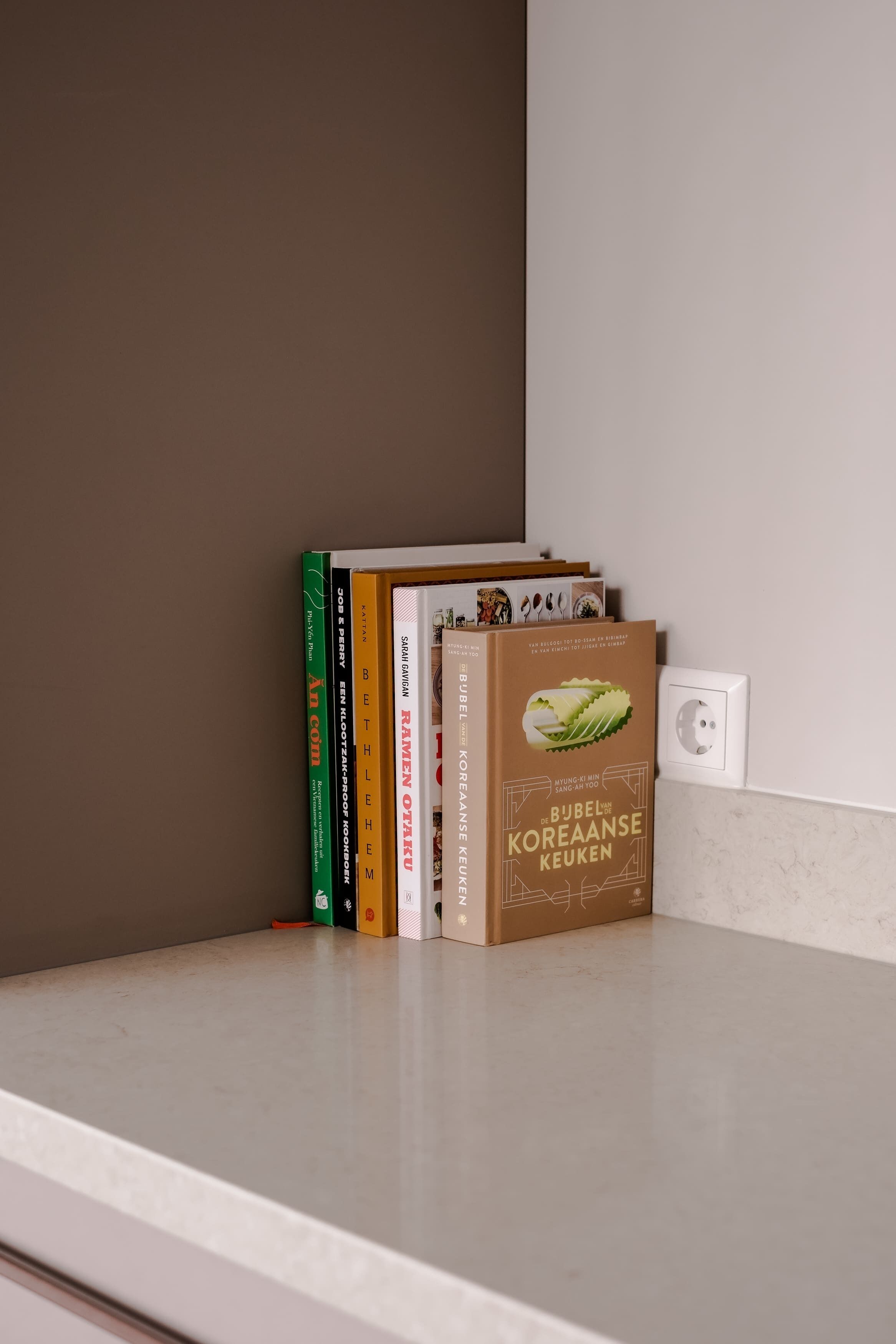 A bookshelf with various books, including titles related to Korean cuisine.