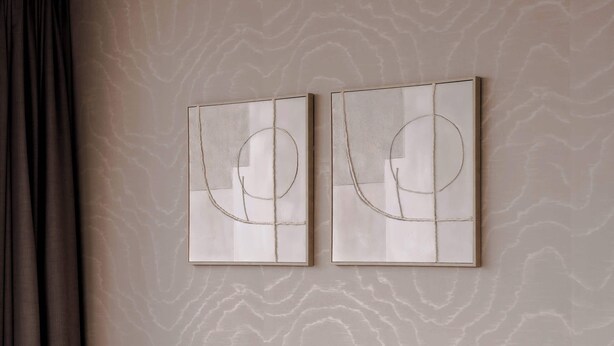 Ein Zimmer mit einem Bett, einem an der Wand hängenden Kunstwerk und einer Steckdose.