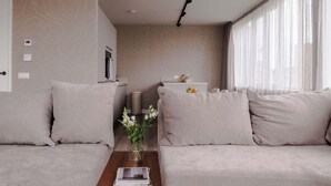 Ein modernes Wohnzimmer mit einer Couch, einem Couchtisch und einem weißen runden Tisch.