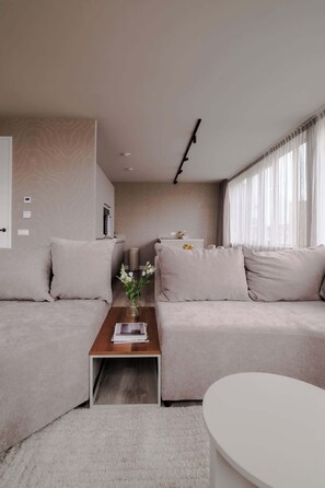 Ein modernes Wohnzimmer mit einer Couch, einem Couchtisch und einem weißen runden Tisch.