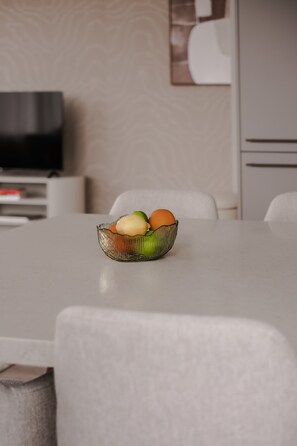 Ein Esstisch mit einer Obstschale in der Mitte.