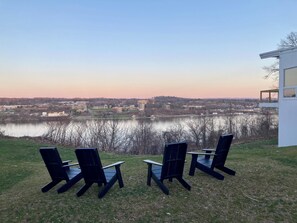 Aussicht auf einen See mit Außenbestuhlung und einem modernen Gebäudebau.
