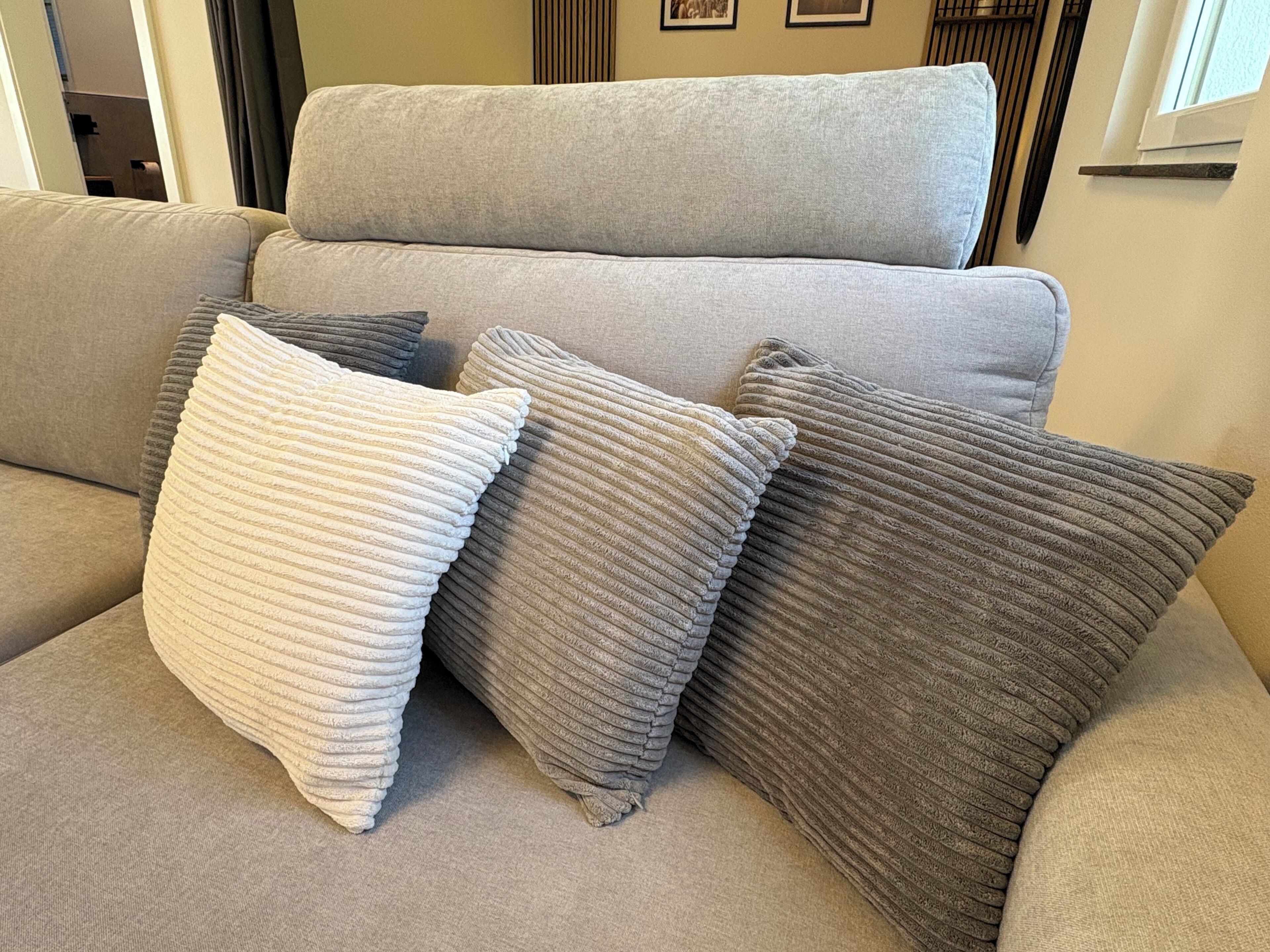 A sofa with three pillows.