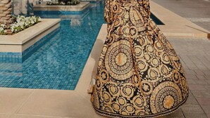 A woman standing by a pool with palm trees and a tall building in the background. - Business Bay Hotel Apartment (Dubai)