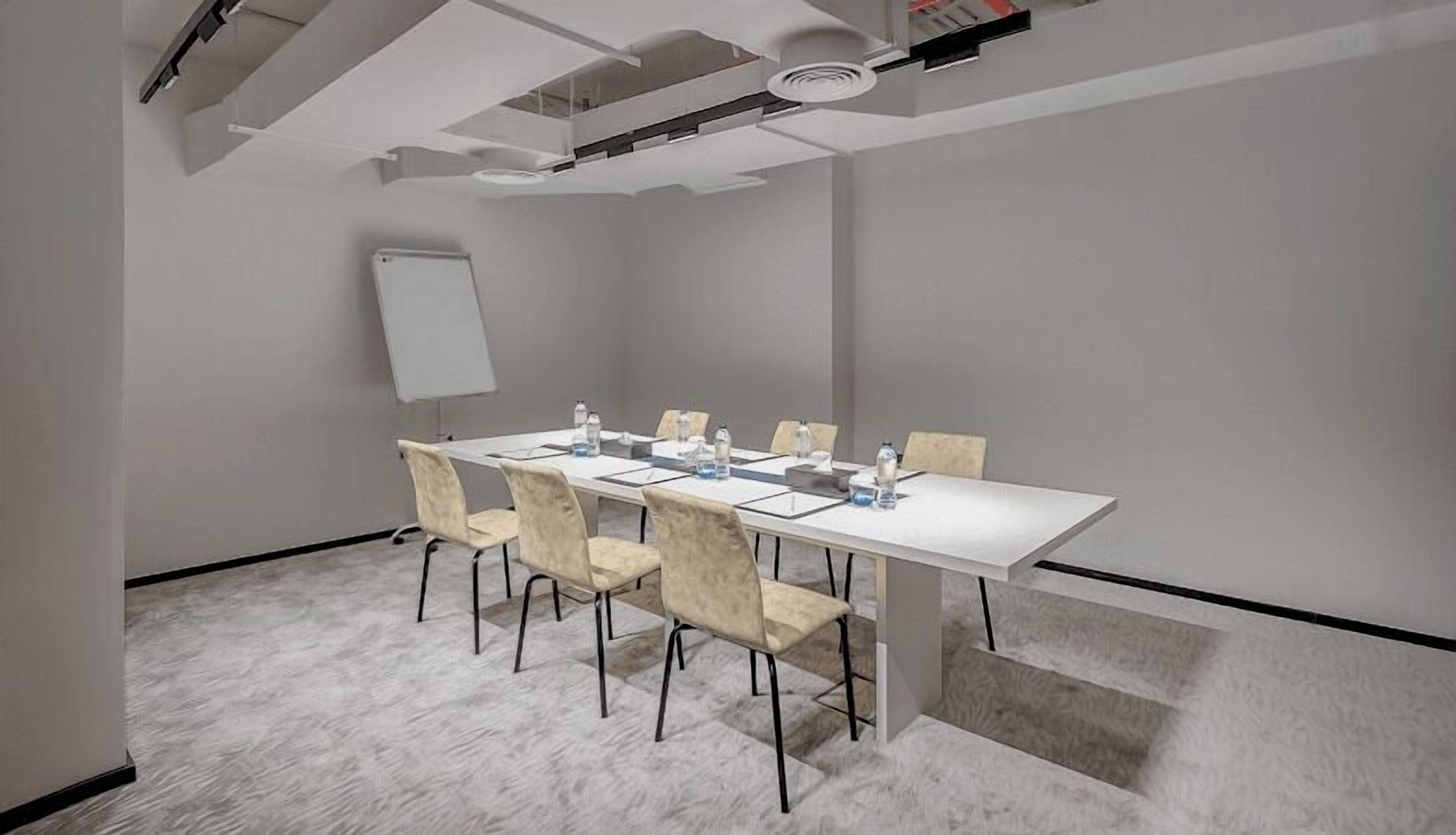 A conference room with a white table, beige chairs, a whiteboard, and a carpeted floor.