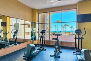 A gym with exercise equipment and large windows overlooking a beach. - Beachfront 1BR Penthouse Sonoran Spa N805 (Puerto Peñasco)
