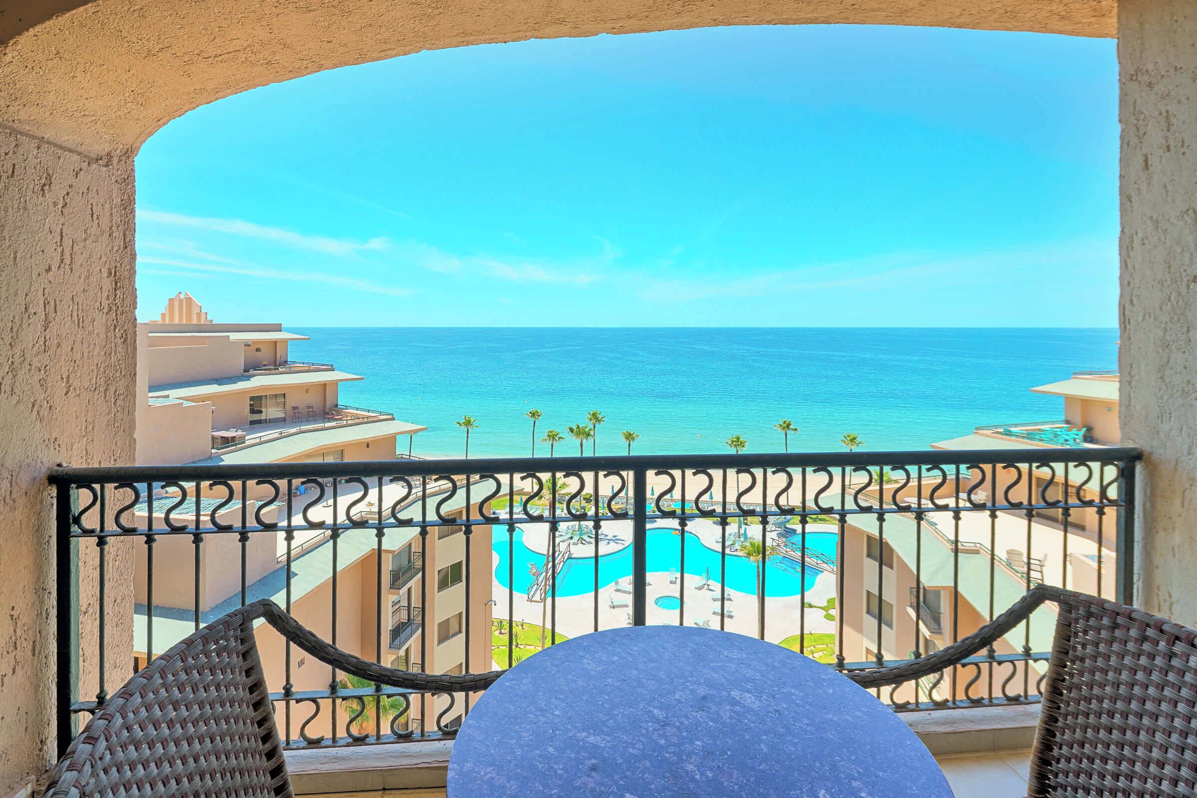 Ein Balkon mit Blick auf einen Swimmingpool und den Ozean.