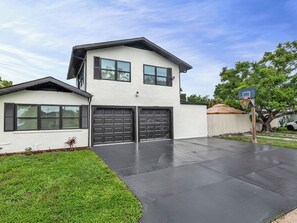 A two-story house with a garage, a basketball hoop, and a well-maintained lawn. - Beautiful 3-bedroom home with pool near beaches and attractions (Palmetto)