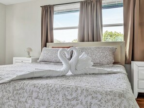A neatly made bed with a swan-shaped pillow and a swan-shaped blanket. - Beautiful 3-bedroom home with pool near beaches and attractions (Palmetto)