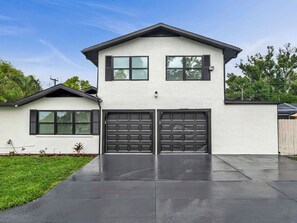 A two-story house with a garage, a flat roof, and a clear sky. - Beautiful 3-bedroom home with pool near beaches and attractions (Palmetto)