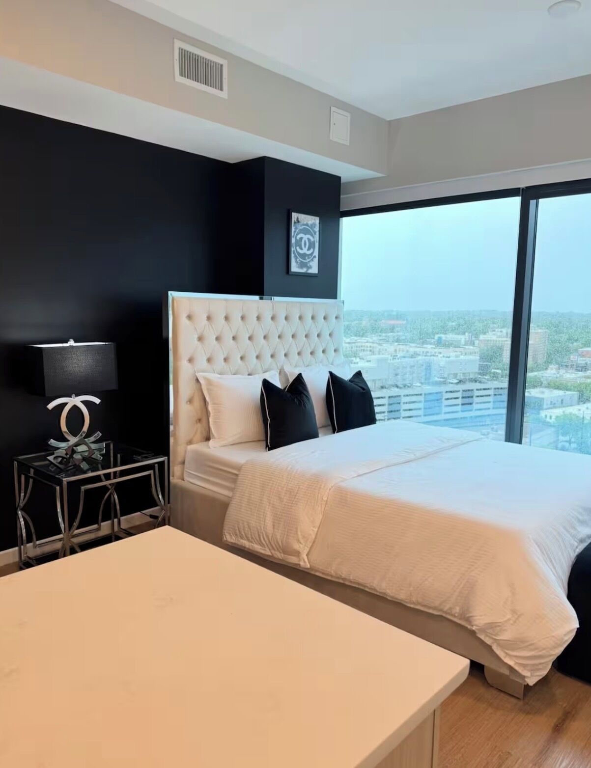 Habitación de hotel moderna con una cama grande, un escritorio y vistas a la ciudad.