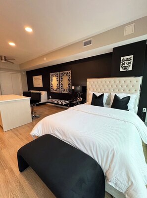 A modern bedroom with a large bed, a desk, and a chair. - Cozy 1-bedroom apartment in fantastic Raleigh with AC and gym access (Raleigh)