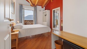 A bedroom with a wooden ceiling, a bed, a desk, and a wardrobe. - Papavero Room with Mountain View, Shared Garden and Wi-Fi (Bivedo-Larido-Marazzone)