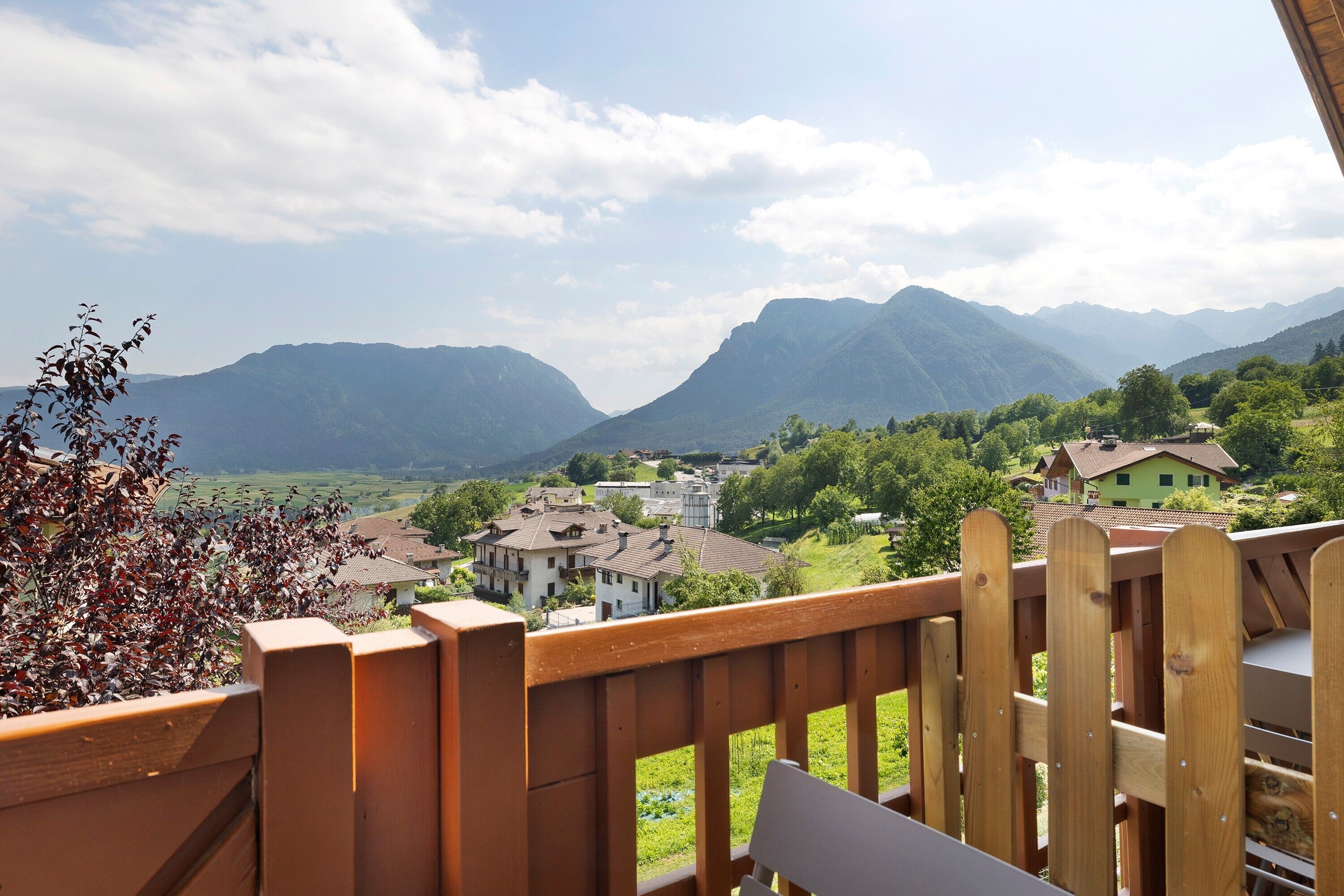 Ein Holzbalkon mit Blick auf ein Dorf und Berge.