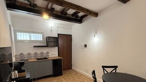 Uma cozinha compacta com área de refeições, piso de madeira e janela.
