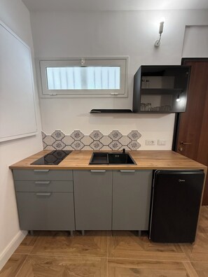 A compact kitchen with a built-in dishwasher, a window above the sink, and a backsplash with a geometric pattern. - Calderai Suite, Palermo. Charming Apartment in Palermo's Historic Center (Palermo)