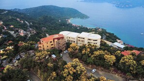 An aerial view of a coastal area with buildings, a road, and a body of water. - Ocean View Two-Bedroom Villa at Cerro del Vigia (Zihuatanejo)