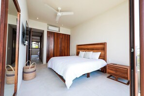 Una camera da letto con un letto, un armadio in legno, un comodino e una ventola a soffitto.