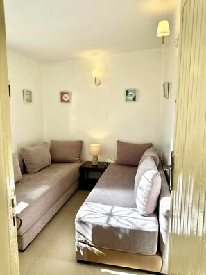 A small, cozy room with two single beds, a nightstand, and wall-mounted lamps. - Family villa with no neighbors directly across the street, 5 minutes from the beach - Sidi Bouzid (Sidi Bouzid)