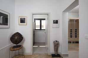 A hallway with a wooden floor, a door leading to a room, and a small stool with a sculpture on it. - Villa BB near Rovinj (Bale)