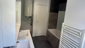 Een badkamer met een wastafel, spiegel, toilet en douchehoek.