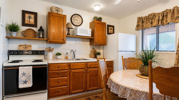 A kitchen with wooden cabinets, a stove, a microwave, and a dining area with a table and chairs. - 3 Bedroom Lakefront Escape: Family Fun, Fishing & Fireside Nights (Camdenton)