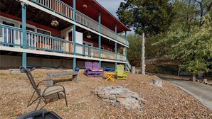 A two-story building with a porch, outdoor seating, and a fire pit. - 3 Bedroom Lakefront Escape: Family Fun, Fishing & Fireside Nights (Camdenton)