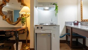 Una kitchenette compacta con estufa, pileta y heladera pequeña.