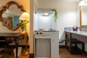Una kitchenette compacta con estufa, pileta y heladera pequeña.