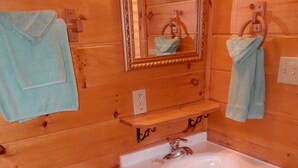 Une salle de bain en bois avec des toilettes, un lavabo et un miroir.