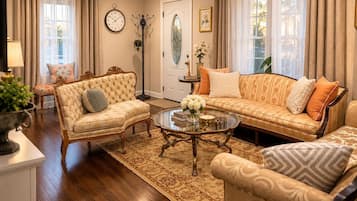 A living room with a sofa, armchairs, a coffee table, and a rug.