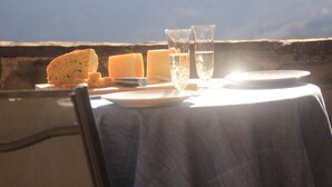 A table set with bread, cheese, and glasses of water, with a view of the sky. - A sustainable and eco-friendly stone house near the Cinque Terre. (Villecchia)
