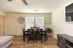 A dining area with a table, chairs, and a potted plant.