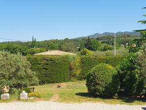 A rural landscape with a house surrounded by lush greenery and hills in the background. - La Belle Aupsoise - AUPS (AUPS)