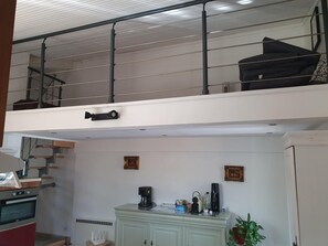 Een moderne keuken met een ingebouwde oven en een eethoek met een lichtkleurige kast.