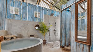 A bathroom with a bathtub, shower, and a potted plant. - Boutique Safari #2 (La Cruz)