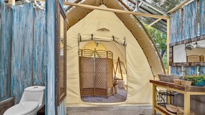A tented bathroom with a toilet, a sink, and a small table with baskets. - Boutique Safari #2 (La Cruz)