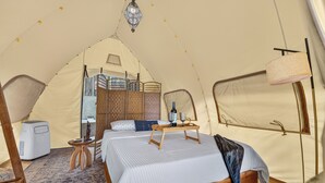 A tent with a bed, a small table, a chair, and a heater. - Boutique Safari #2 (La Cruz)