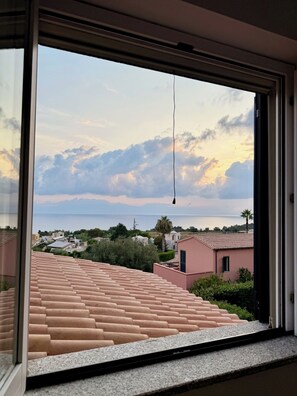 A view from a window overlooking a coastal area with terraced roofs and a clear sky. - Casa Sciaría: Relaxation with a Sea View in the Heart of the Costa degli Dei (Calabria)