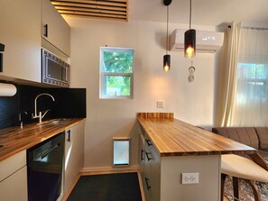 Eine moderne Küche mit Holzarbeitsplatte, integrierten Geräten und einem Fenster für natürliches Licht.