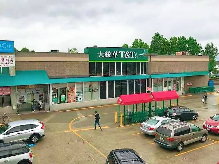 Una tienda T&T con toldo verde y un letrero en un idioma extranjero.