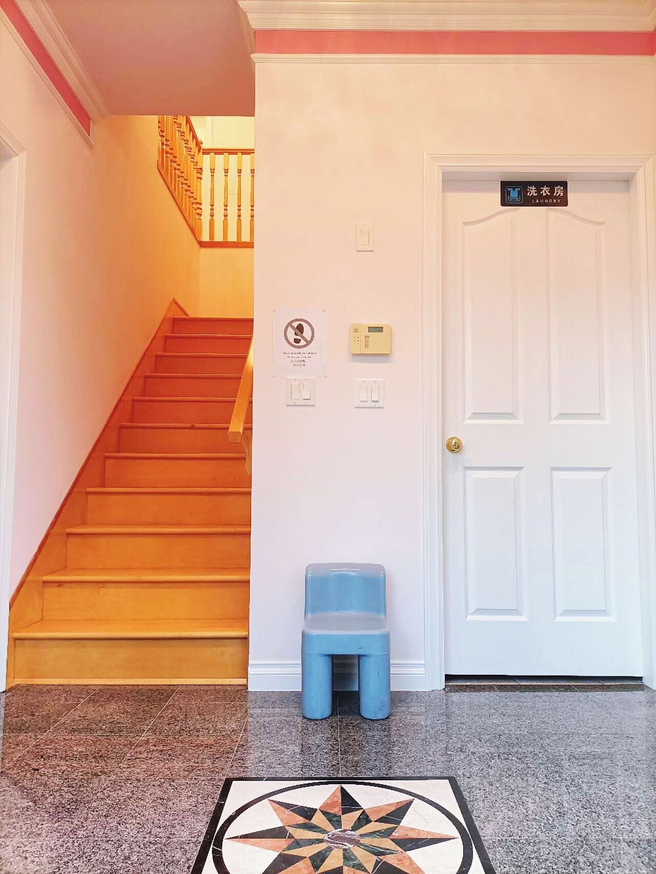 A staircase leading to a door with a sign indicating a laundry room.
