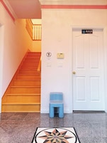 Escadas que levam a uma porta com uma placa indicando lavanderia.