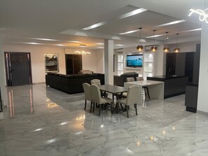 A modern interior with a dining area, a living room, and a kitchen.